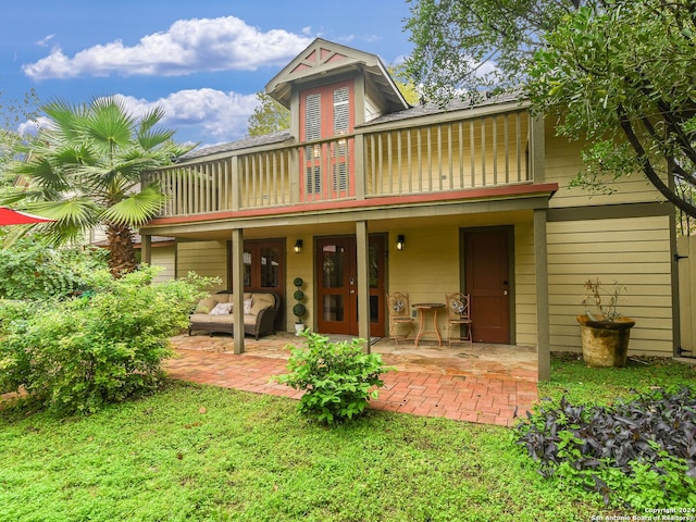 back of property featuring a patio area and a balcony