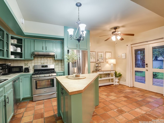 kitchen featuring a center island, hanging light fixtures, butcher block countertops, backsplash, and appliances with stainless steel finishes