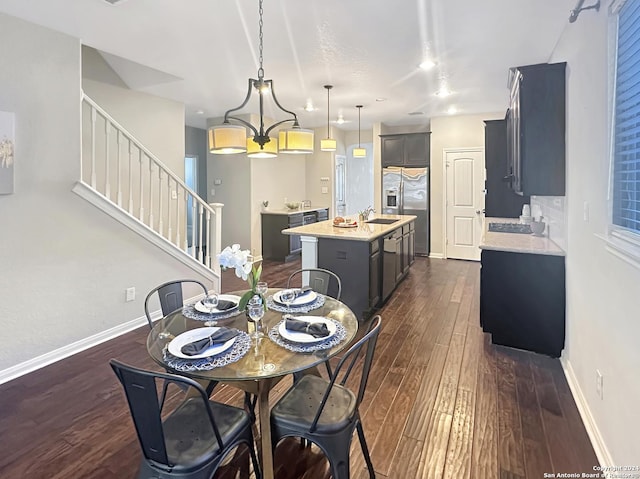 dining space featuring sink, dark hardwood / wood-style floors, and an inviting chandelier