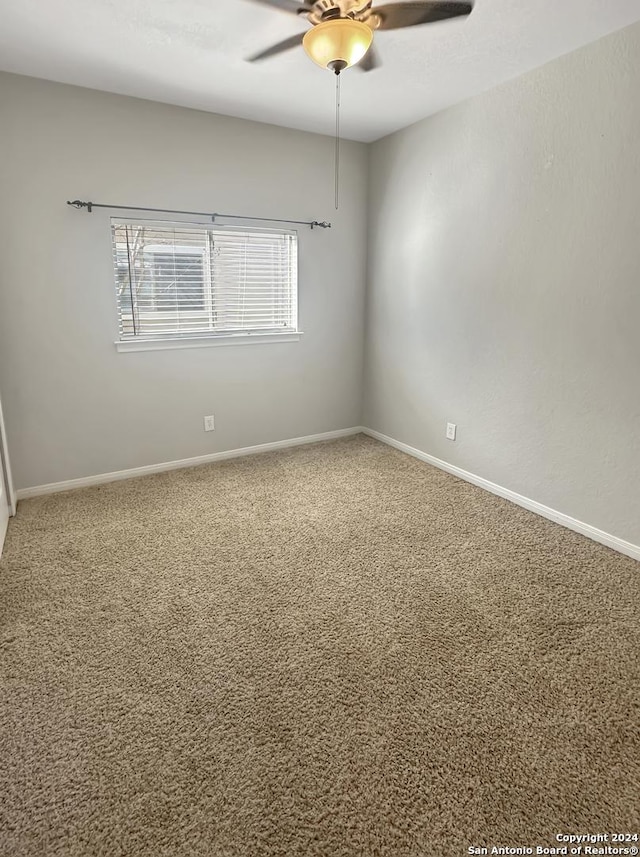 carpeted spare room featuring ceiling fan