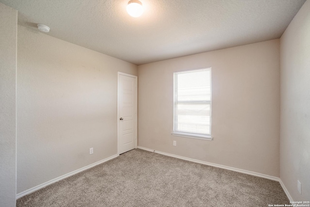 empty room featuring light carpet and a textured ceiling