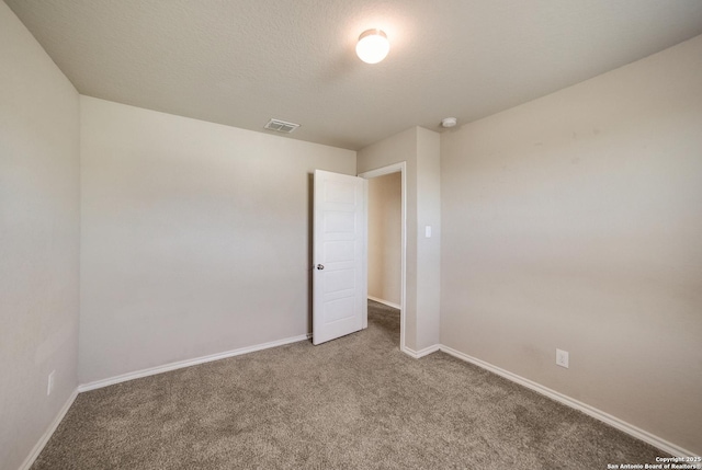 carpeted empty room with a textured ceiling