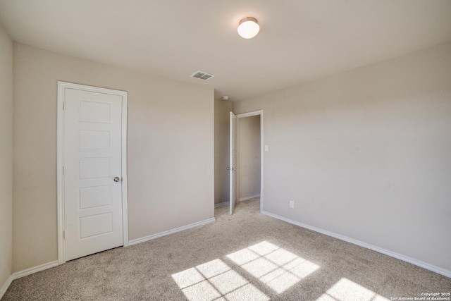 unfurnished bedroom with light colored carpet and a closet