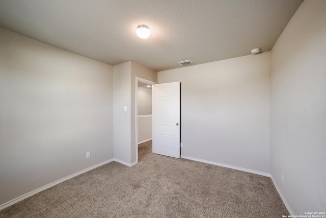 empty room featuring light carpet and a textured ceiling