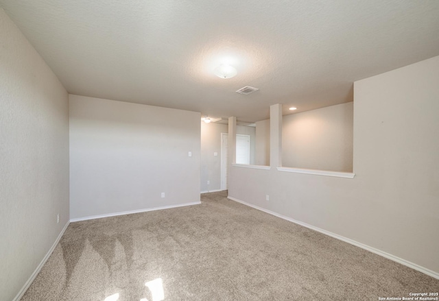 spare room featuring carpet and a textured ceiling