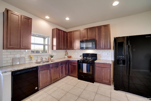 kitchen featuring light tile patterned floors, sink, light stone counters, and black appliances