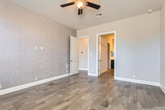 spare room featuring ceiling fan and dark hardwood / wood-style floors