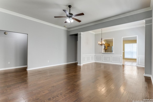 spare room featuring dark hardwood / wood-style flooring, ceiling fan with notable chandelier, decorative columns, and crown molding