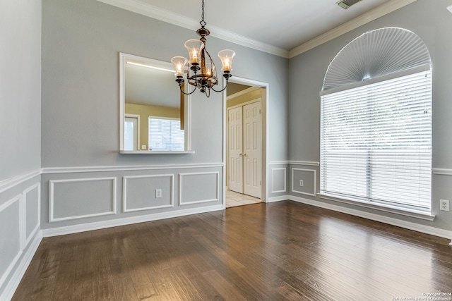 unfurnished room featuring hardwood / wood-style flooring, a notable chandelier, crown molding, and a wealth of natural light