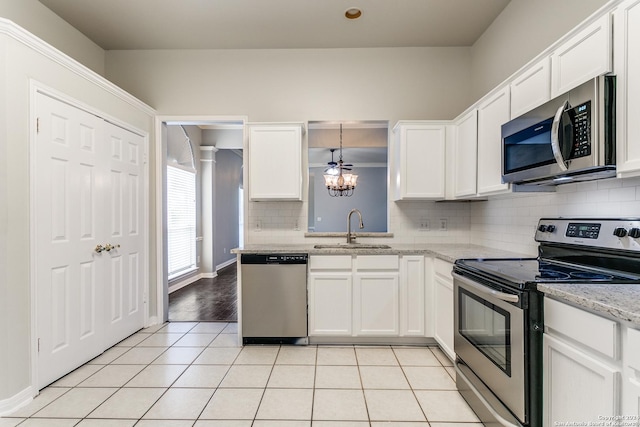 kitchen with pendant lighting, stainless steel appliances, white cabinetry, and sink