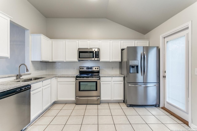 kitchen with white cabinets, appliances with stainless steel finishes, light stone counters, and sink