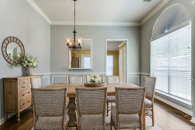 dining area featuring a notable chandelier, dark hardwood / wood-style floors, and ornamental molding