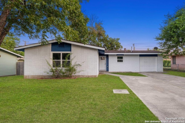 ranch-style home featuring a garage and a front yard