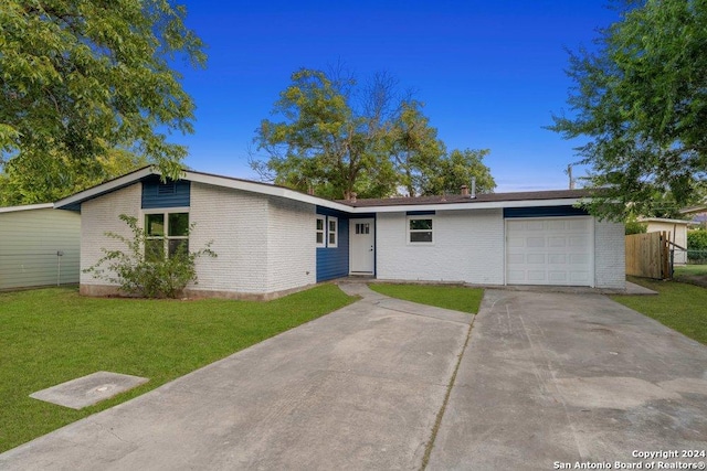 ranch-style home featuring a garage and a front lawn