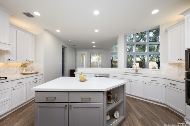 kitchen featuring white cabinets, a center island, gray cabinetry, and sink