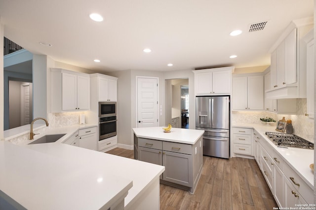 kitchen featuring sink, white cabinets, stainless steel appliances, and light wood-type flooring