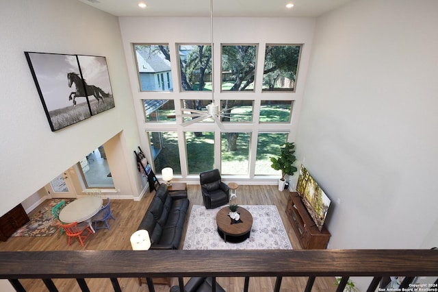 living room with hardwood / wood-style floors, ceiling fan, and a high ceiling