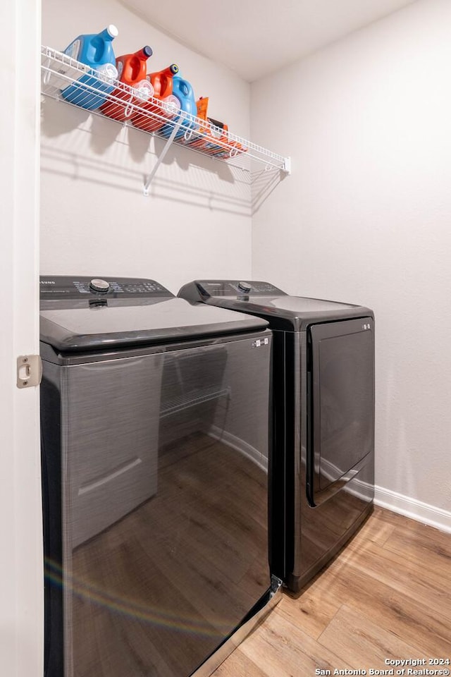 laundry area with washer and clothes dryer and hardwood / wood-style floors