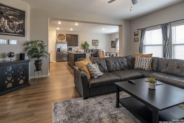 living room featuring hardwood / wood-style floors, ceiling fan, and sink