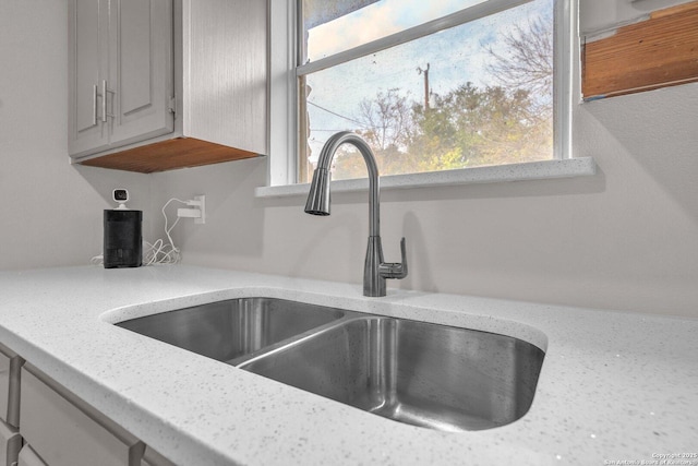 room details with light stone countertops and sink