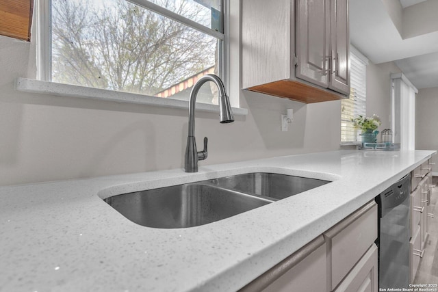 room details with dishwasher, light stone counters, and sink