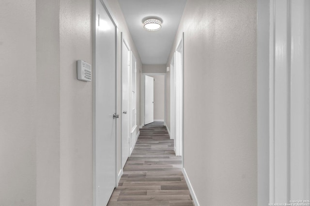 hallway with light hardwood / wood-style floors