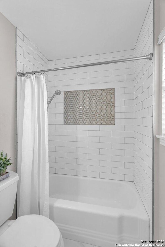 bathroom featuring toilet and shower / bathtub combination with curtain