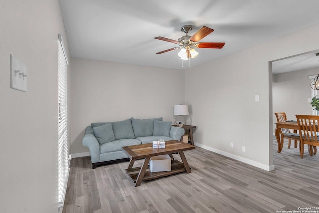 living room with ceiling fan and light hardwood / wood-style flooring