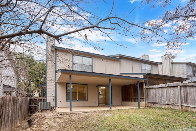 back of house with a patio area, a yard, and central AC