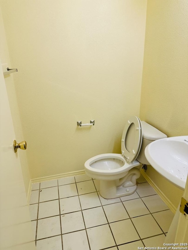 bathroom featuring tile patterned flooring, toilet, and sink