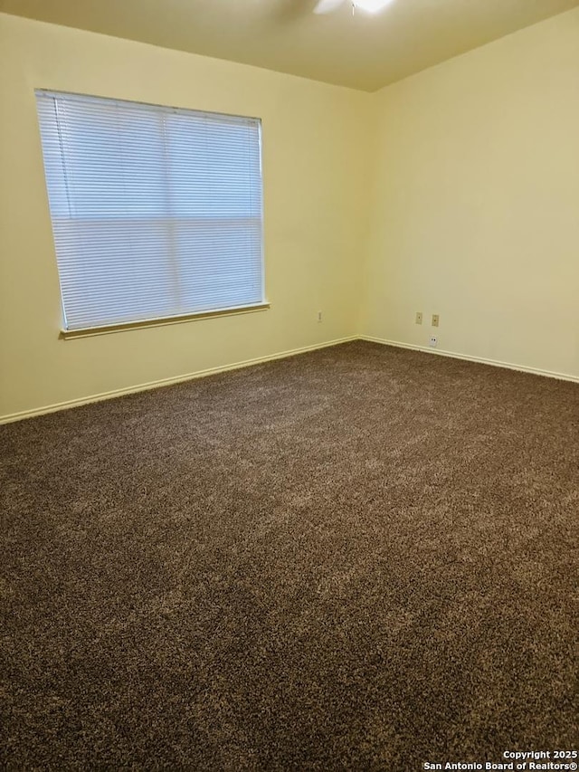 carpeted spare room with ceiling fan