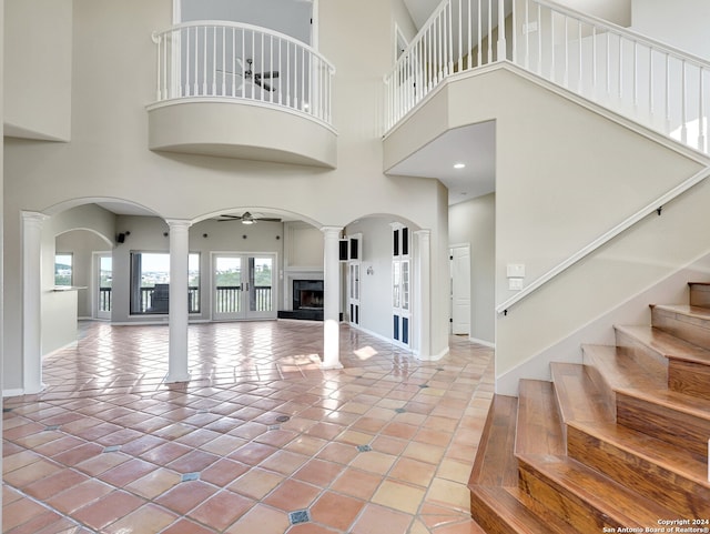 tiled entryway featuring ceiling fan and a high ceiling