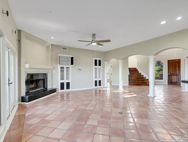 unfurnished living room with a premium fireplace, light tile patterned floors, and ceiling fan