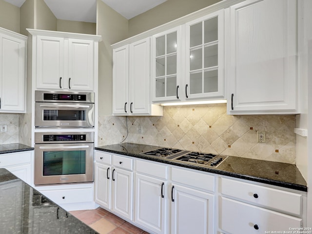 kitchen featuring decorative backsplash, white cabinetry, and appliances with stainless steel finishes