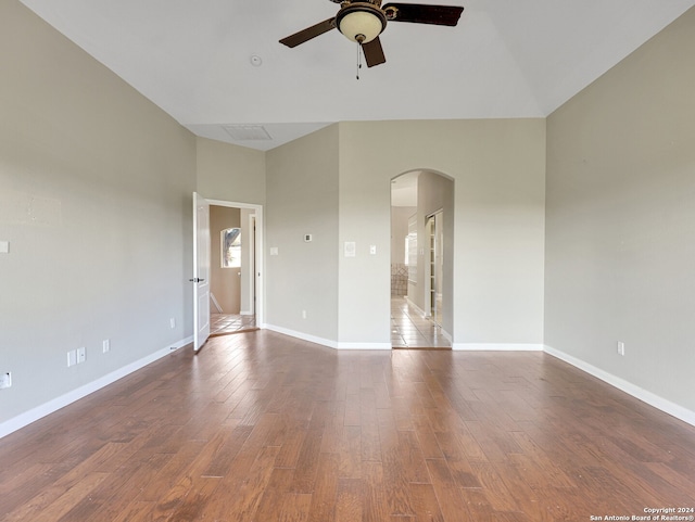 unfurnished room featuring ceiling fan, dark hardwood / wood-style flooring, and vaulted ceiling