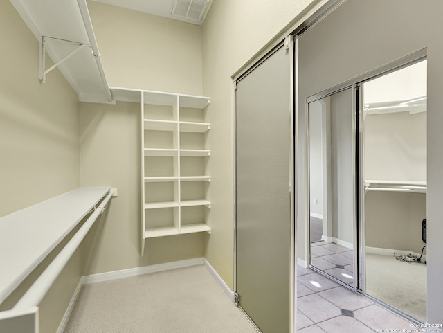 walk in closet with light colored carpet