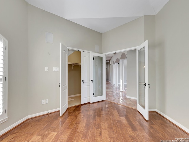 unfurnished bedroom featuring a closet, french doors, and wood-type flooring