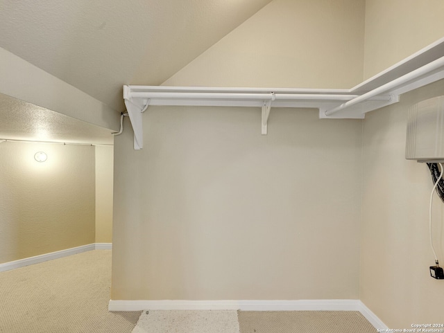 walk in closet featuring carpet floors and vaulted ceiling