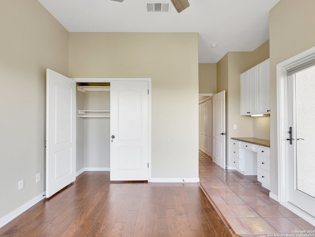 unfurnished bedroom with hardwood / wood-style floors, a closet, and ceiling fan