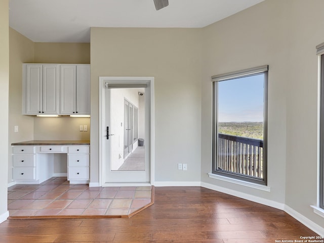 kitchen featuring white cabinetry, built in desk, and light hardwood / wood-style floors