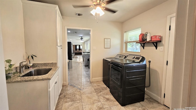 washroom with cabinets, sink, ceiling fan, and washer and dryer