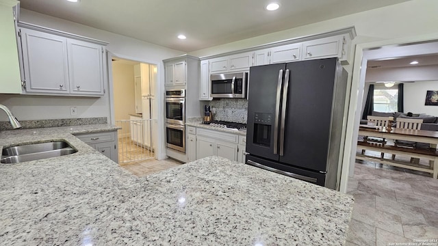 kitchen with backsplash, stainless steel appliances, and sink