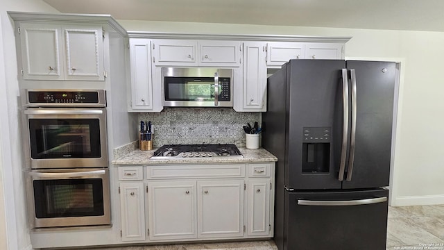 kitchen featuring backsplash, white cabinets, and stainless steel appliances