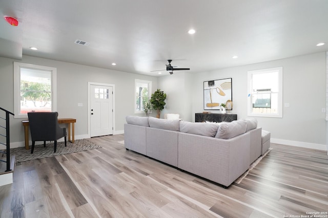 living room with ceiling fan and light hardwood / wood-style flooring