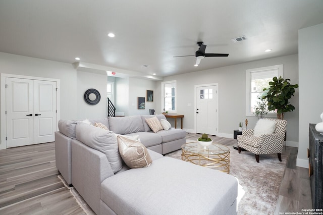 living room with a healthy amount of sunlight, ceiling fan, and light hardwood / wood-style floors