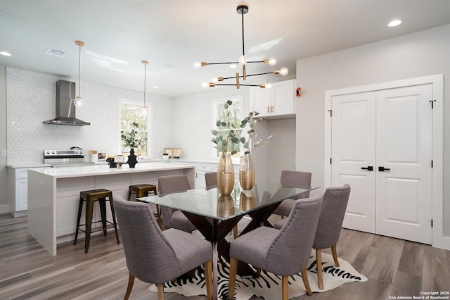 dining space featuring a notable chandelier and light wood-type flooring