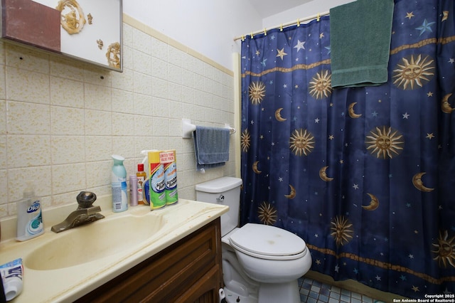 bathroom featuring vanity, tile walls, and toilet