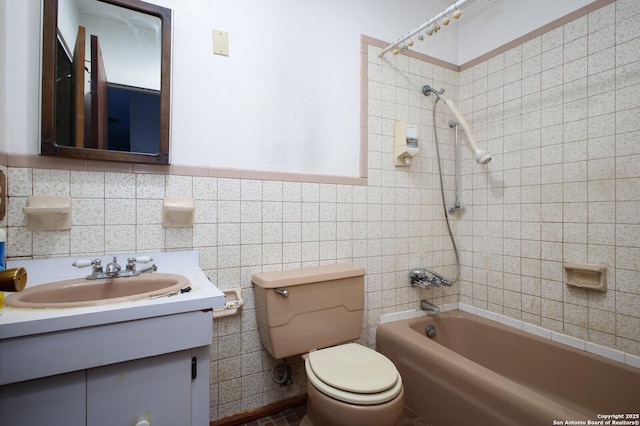 full bathroom featuring vanity, tiled shower / bath combo, tile walls, and toilet