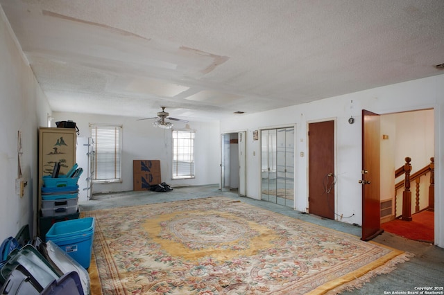 miscellaneous room featuring ceiling fan and a textured ceiling