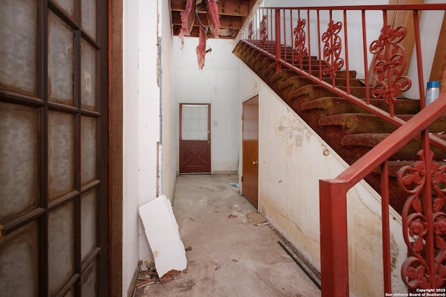 staircase featuring concrete floors